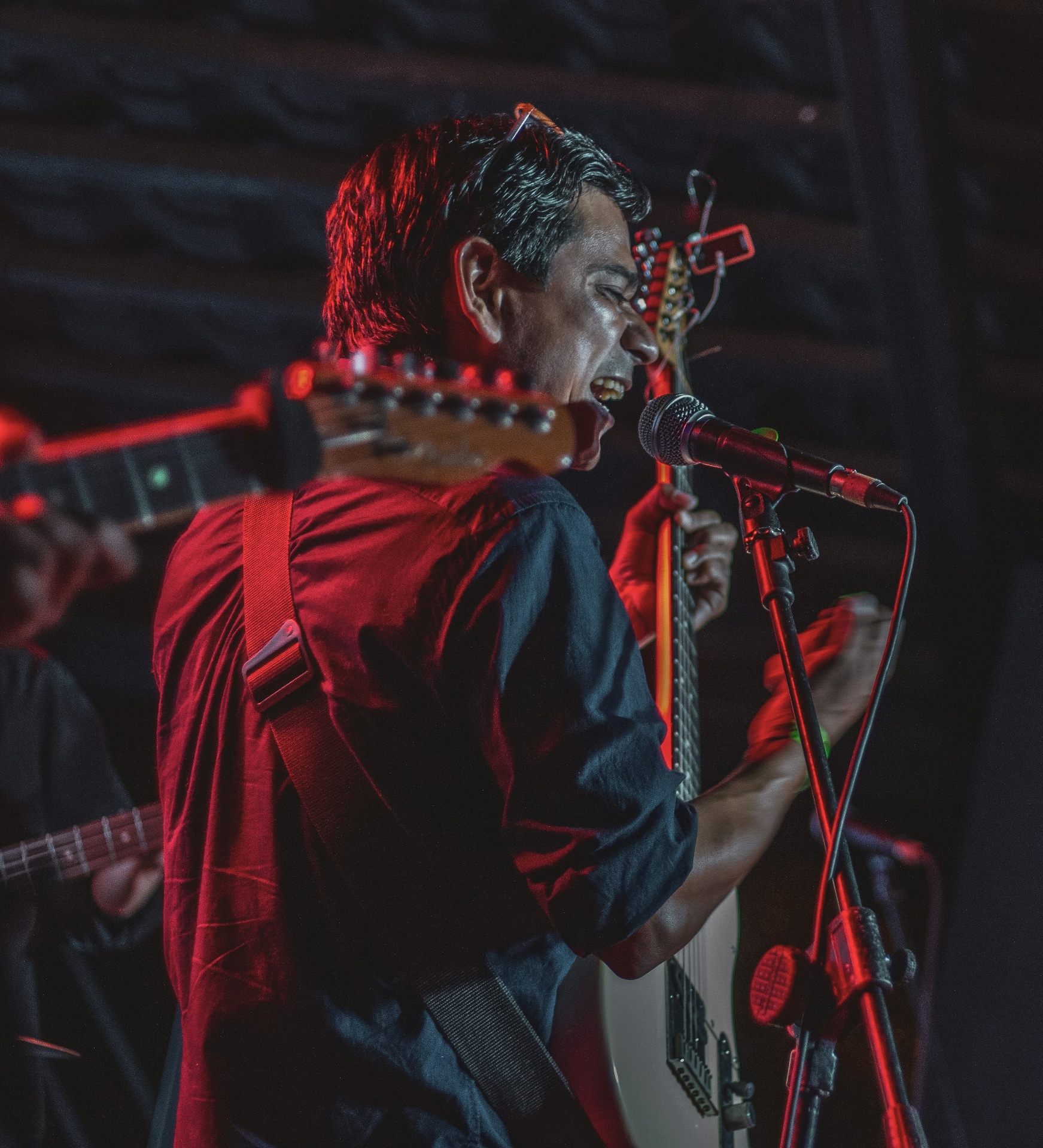 Live vocalist performing on stage under red light